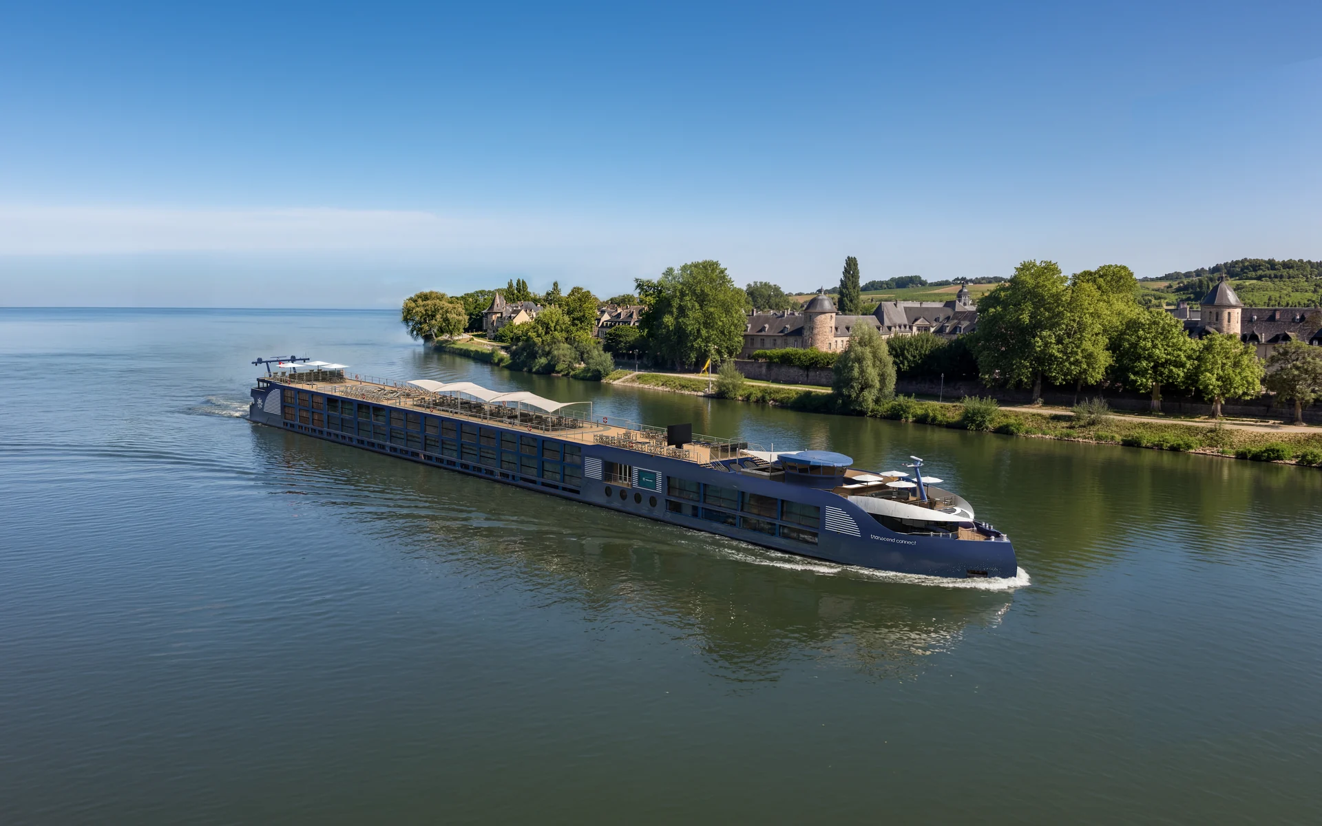Transcend Cruises — aerial three-quarter view approaching a riverside village
