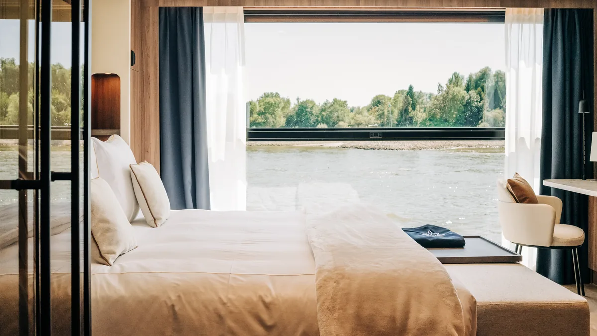 Cabine du Transcend Connect avec très grand lit et fenêtre pleine hauteur sur la rivière